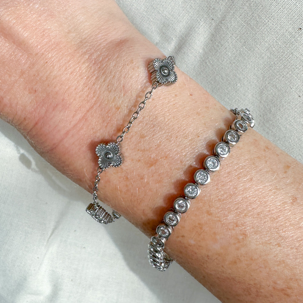 
                  
                    Silver  tennis bracelet with clear CZ bezel set stones on a wrist
                  
                