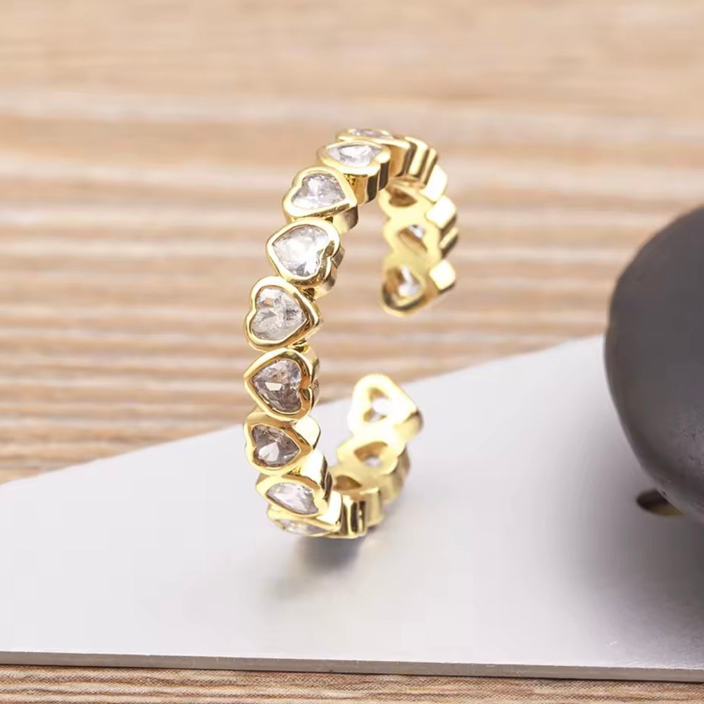 
                  
                    Gold heart-shaped earring on a wooden surface
                  
                