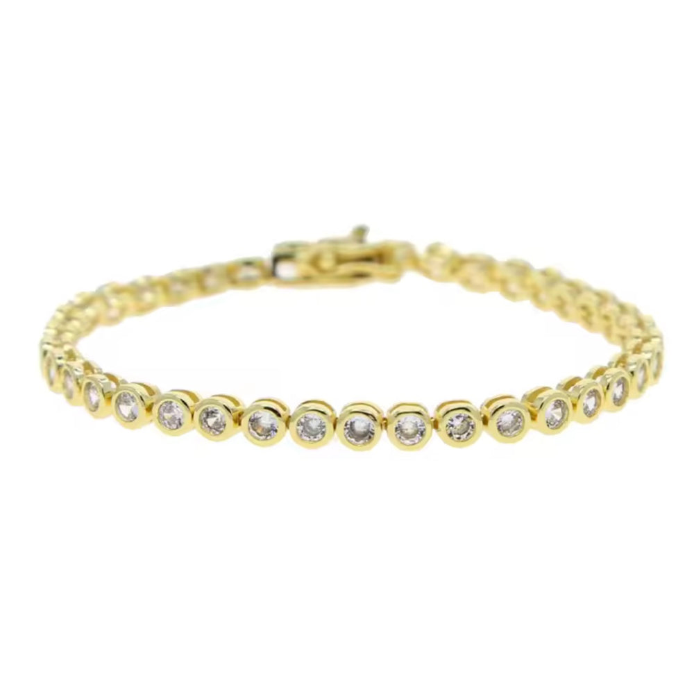 Gold  tennis bracelet with clear Cubic zirconia bezel set stones on a wrist against a neutral background