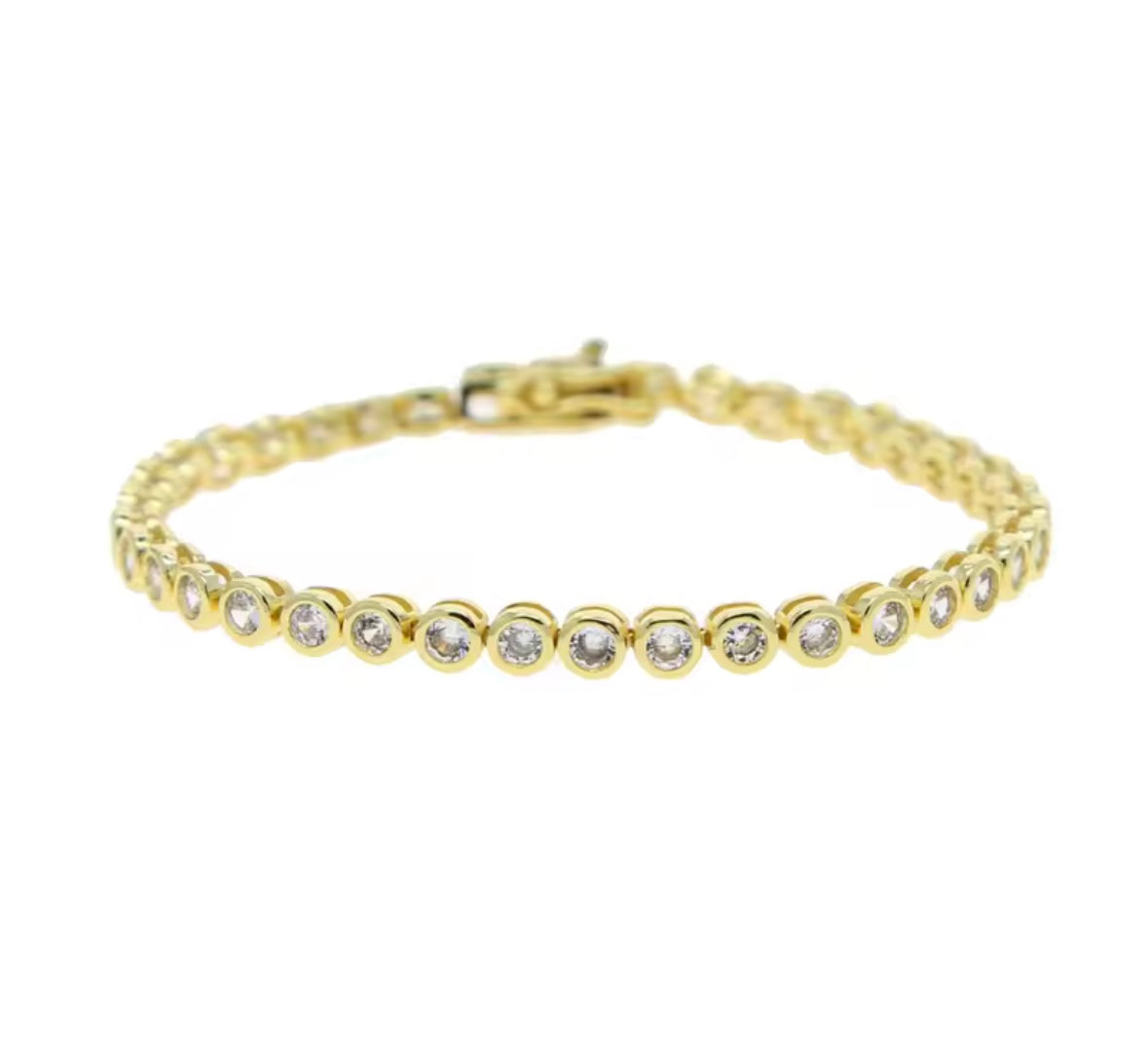 Gold  tennis bracelet with clear Cubic zirconia bezel set stones on a wrist against a neutral background