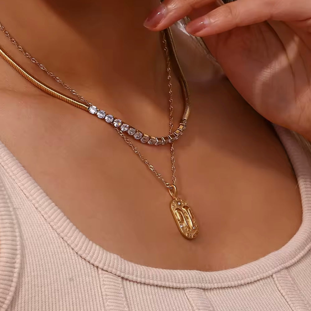 
                  
                    A dainty gold zodiac necklace inspired by vintage tarot cards — finished with sparkling CZ details and a twisted rope chain. 
                  
                