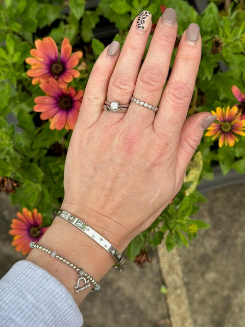 
                  
                    Sterling Silver ring with small CZ bezel set stones on a light background
                  
                
